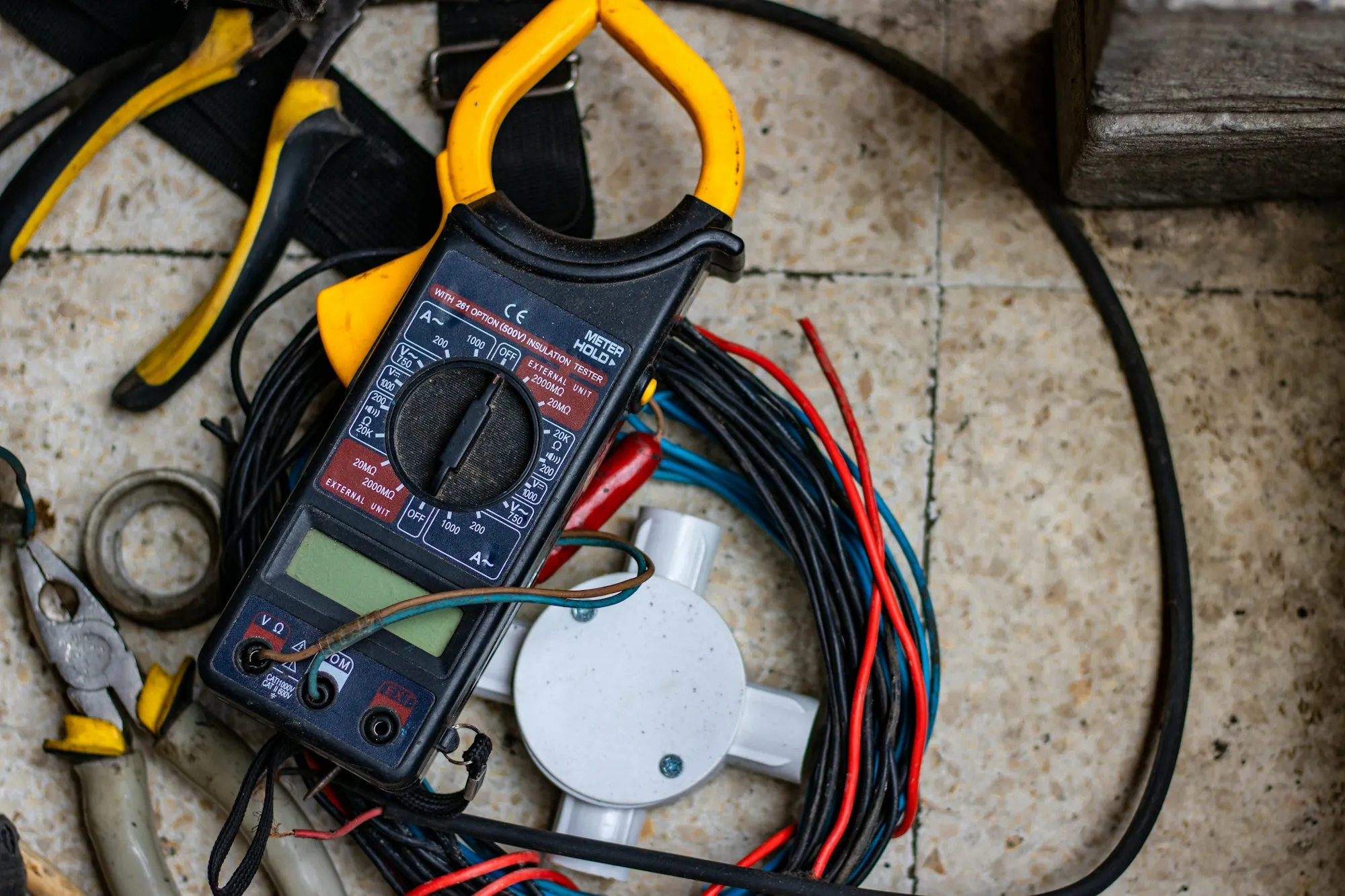 Multimeter and electrical tools on a work surface